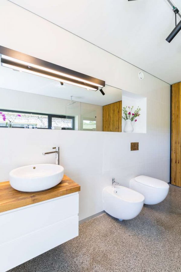 Weißes Badezimmer mit Holzdetails